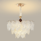Tiered clear textured-glass leaf chandelier with warm metal and dark wood details