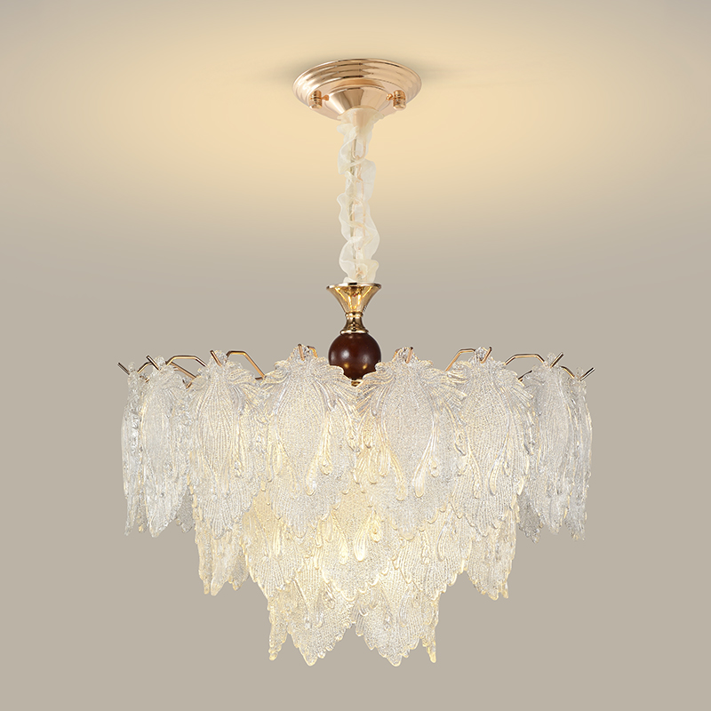 Tiered clear textured-glass leaf chandelier with warm metal and dark wood details