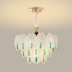 Layered clear glass leaf chandelier with elongated emerald-toned drops