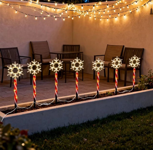 Red tube snowflake stake light with warm white glow in a winter garden - single-set scene
