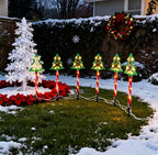 Red tube Christmas tree silhouette stake light glowing warm white outdoors - single-set scene