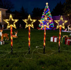 Red tube five-pointed star stake light glowing warm white on a lawn - product shot