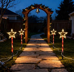 Red tube five-pointed star stake light glowing warm white on a lawn - single-set scene