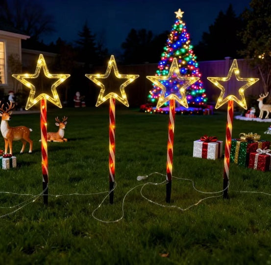 Red tube five-pointed star stake light glowing warm white on a lawn - product shot
