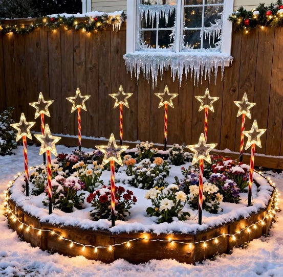Red tube five-pointed star stake light glowing warm white on a lawn - multi-set scene